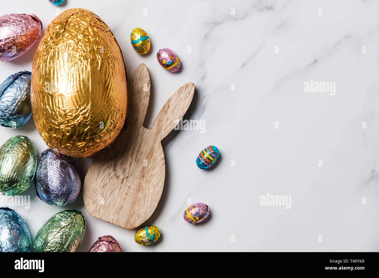 Lapin de Pâques avec les oeufs de pâques en chocolat emballé d'aluminium Banque D'Images