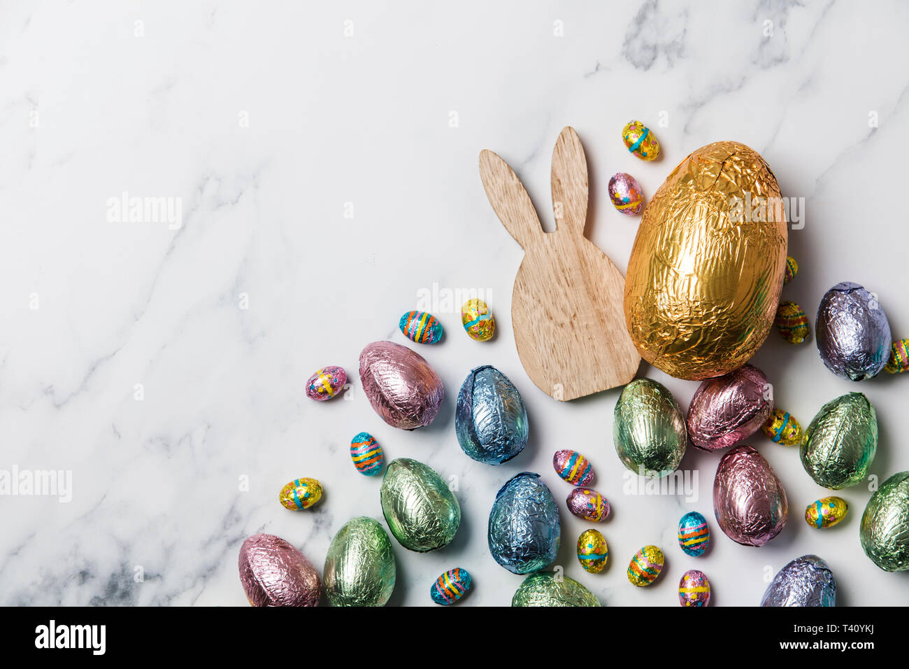 Lapin de Pâques avec les oeufs de pâques en chocolat emballé d'aluminium Banque D'Images