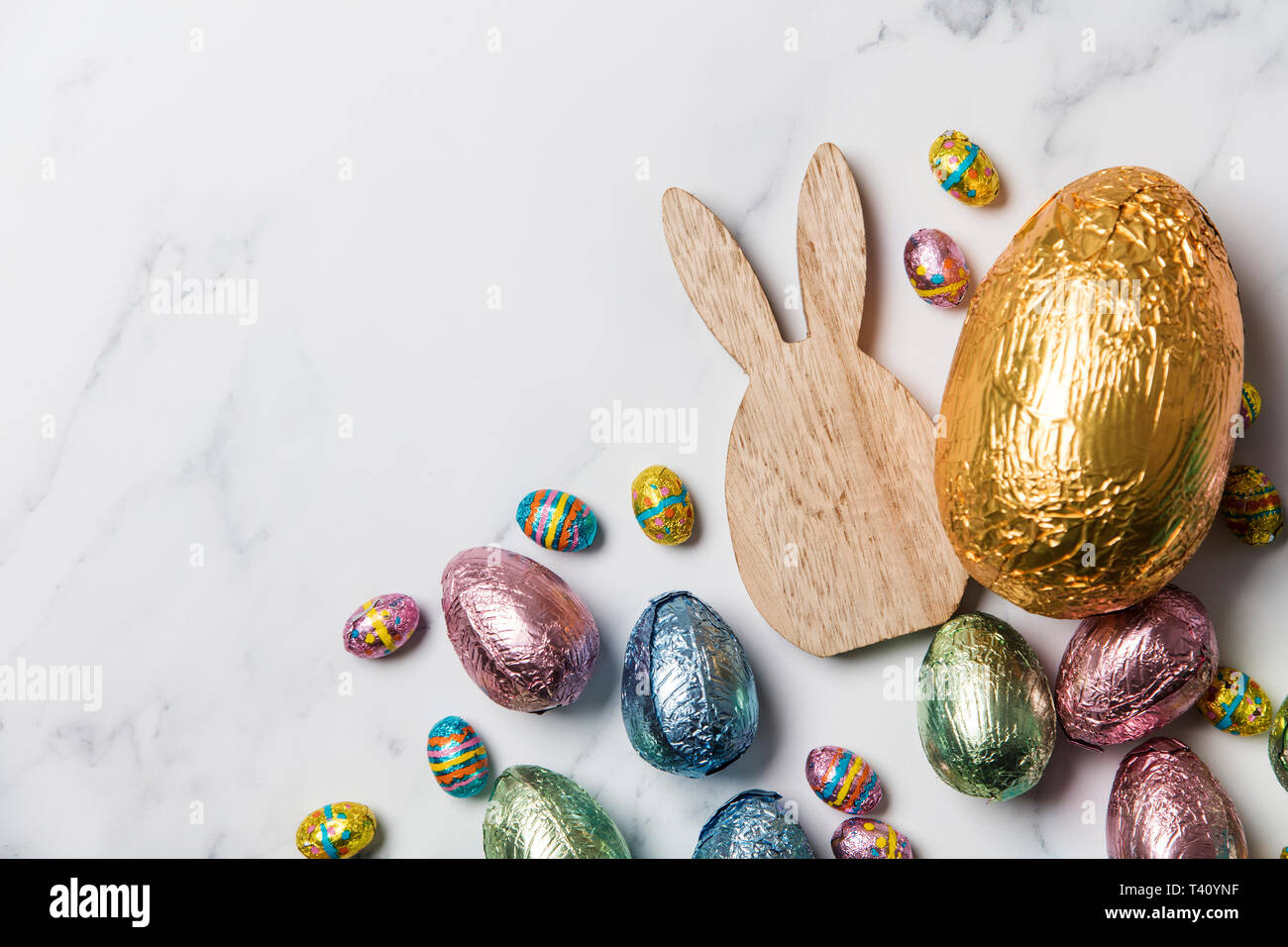 Lapin de Pâques avec les oeufs de pâques en chocolat emballé d'aluminium Banque D'Images