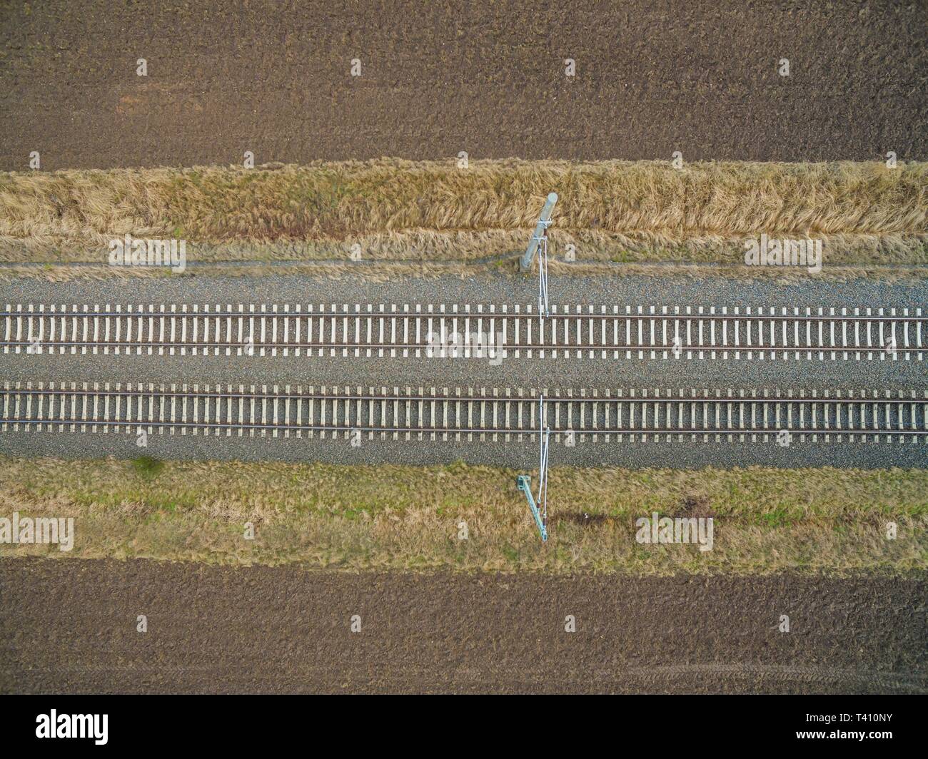 Vue aérienne de voies de chemin de fer dans l'arrière-pays entre terres agricoles fraîchement labourés - Vue de dessus de la voie ferrée Banque D'Images