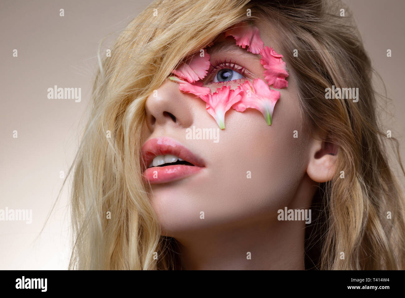 Blonde-haired model avec lèvres roses pétales ayant autour de blue eye Banque D'Images