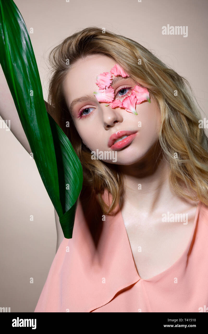 Offres blue-eyed model avec les lèvres roses et eyeshades holding leaf Banque D'Images