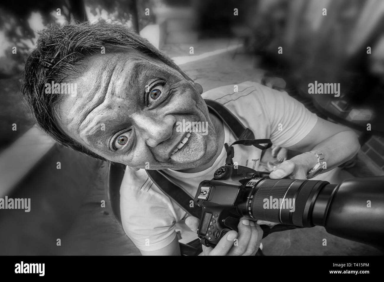 Close-up d'un journaliste / photographe avec appareil photo et le crazy face comique Banque D'Images