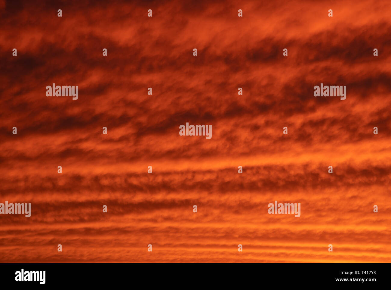 Maquereaux ciel au coucher du soleil avec des nuages orange et jaune à travers la vue vallonnée Banque D'Images