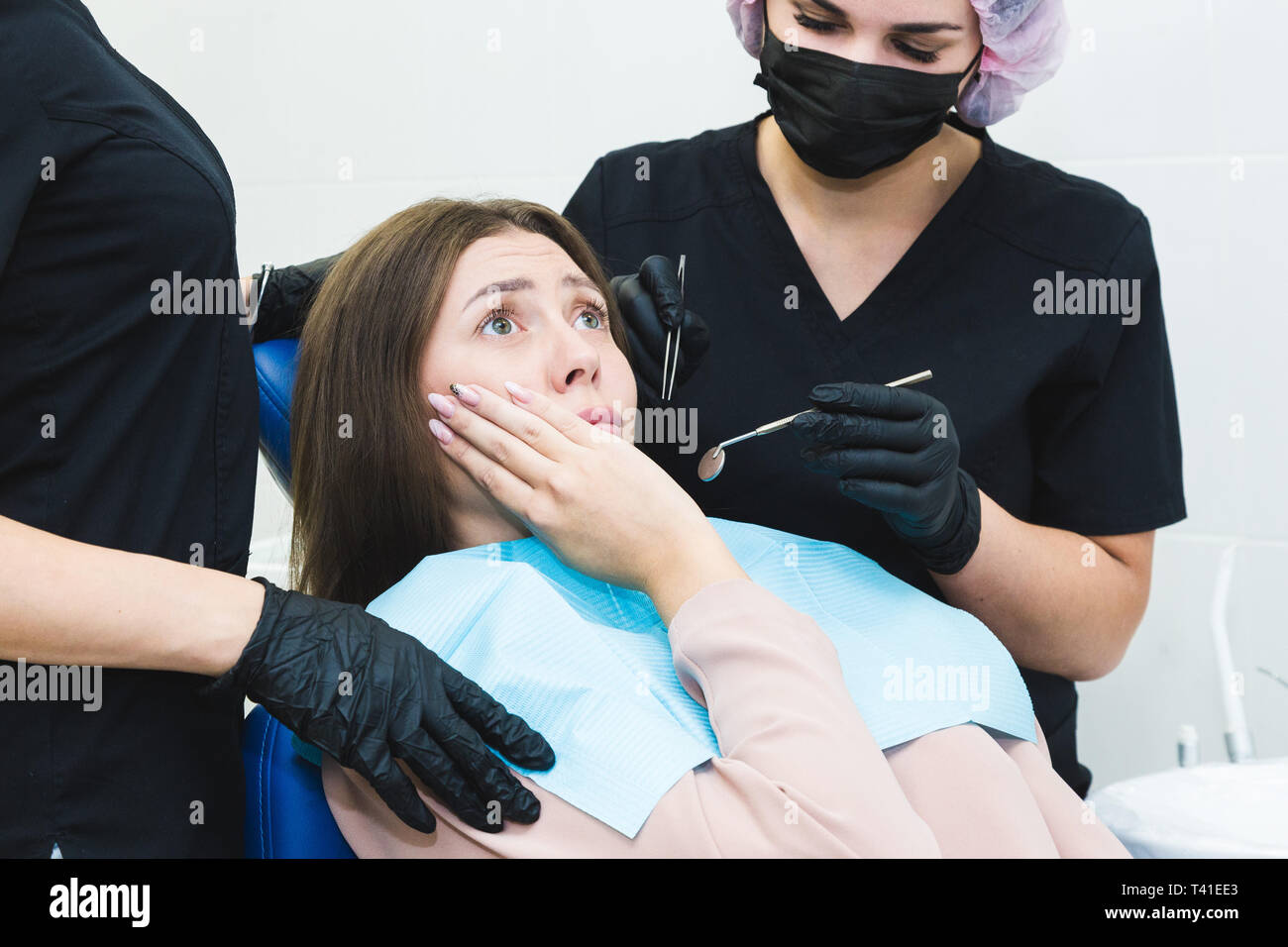 Clinique dentaire. La réception, l'examen du patient. Soins des dents. Jeune femme sent la douleur chez le dentiste. Banque D'Images