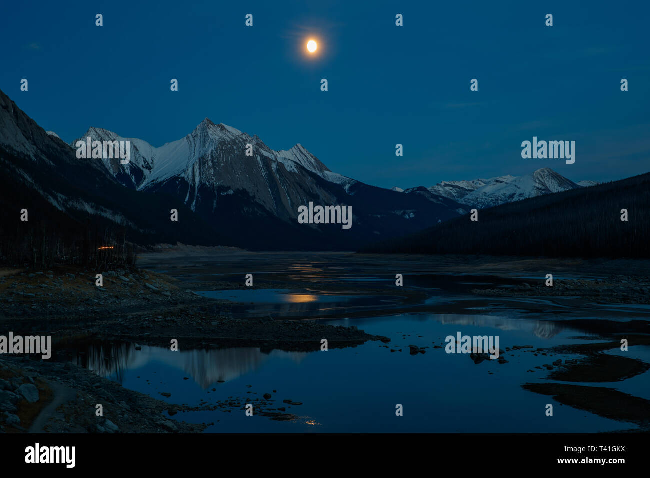 La lune dans la nuit sur le lac Medicine et de la Reine Elizabeth de montagnes dans le Parc National de Jasper, Canada Banque D'Images