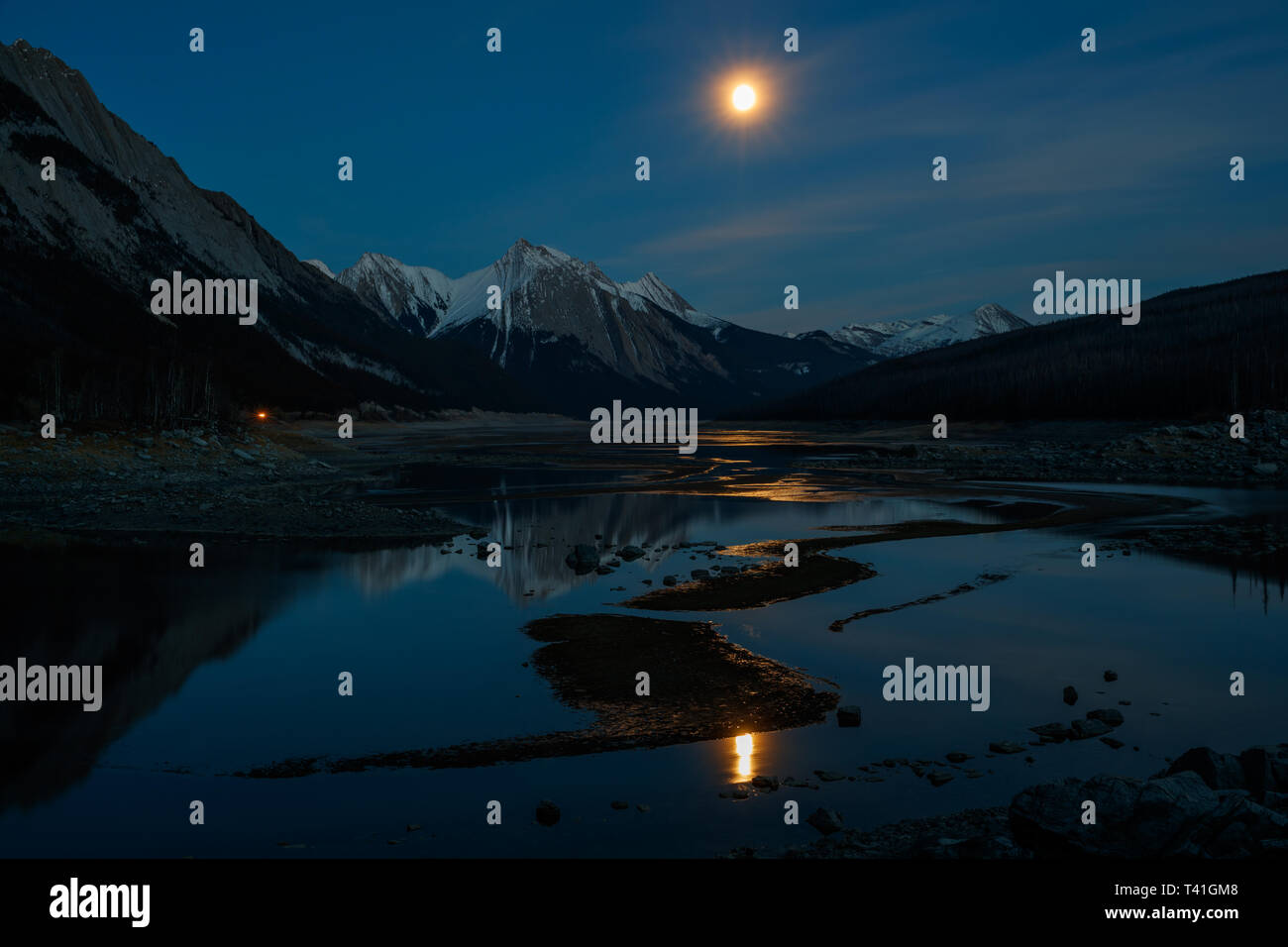 La lune dans la nuit sur le lac Medicine et de la Reine Elizabeth de montagnes dans le Parc National de Jasper, Canada Banque D'Images