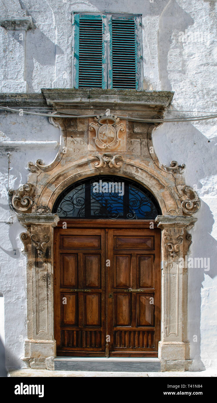 Ostuni, Pouilles, Italie, 22 mars 2019 : Façade d'immeuble ancien avec une magnifique porte dans la vieille ville d'Ostuni, la Citta Bianca Banque D'Images