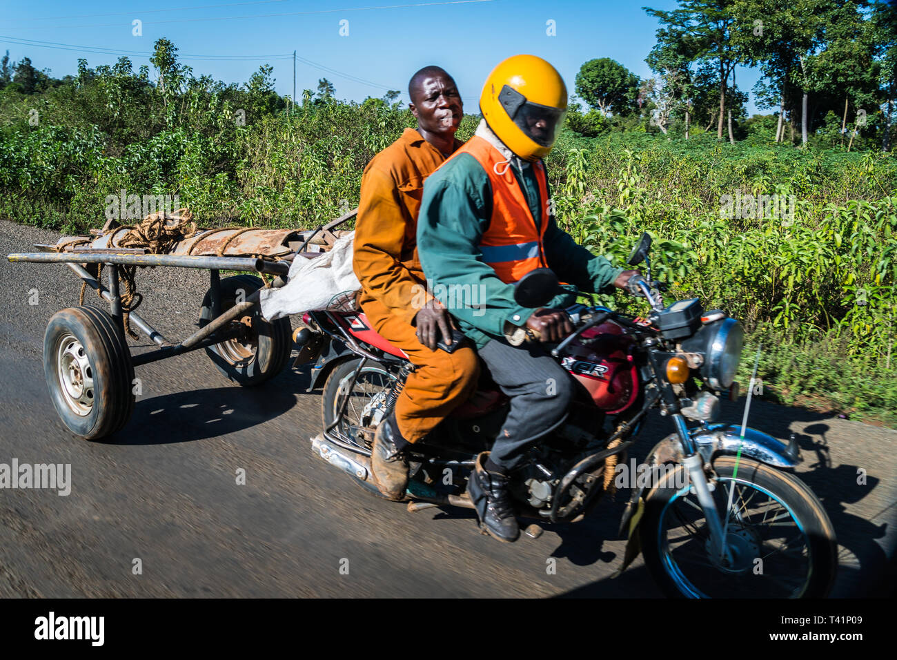 Près de Kisumu, Kenya - 8 mars 2019 - les hommes de monter une moto avec une remorque dans la campagne Banque D'Images