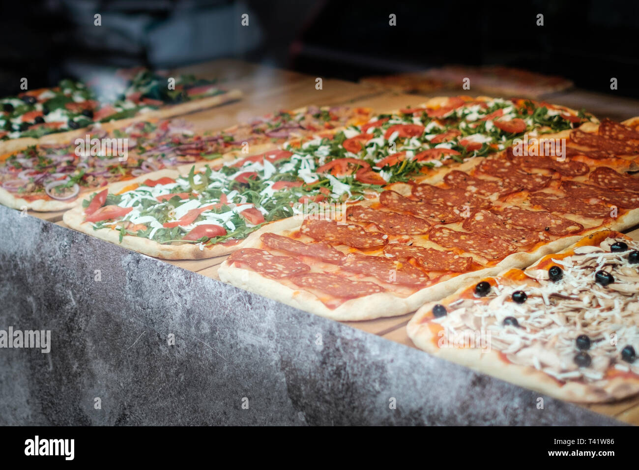 Pizza à la vente, tranche de pizza derrière la fenêtre d'affichage Banque D'Images