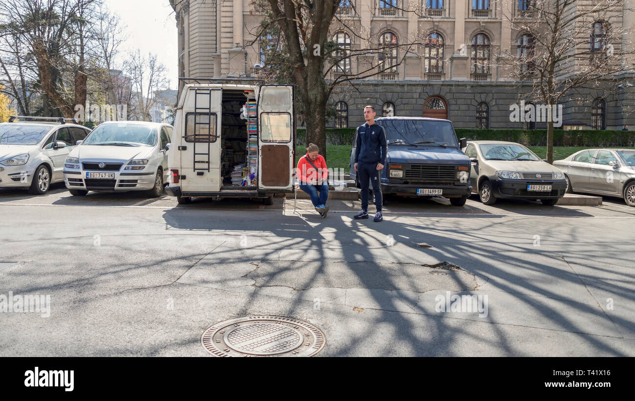 Belgrade, Serbie, le 30 mars 2019 : scène de rue à Kosovska Rue avec femme et homme vente de livres scolaires à partir d'un van stationné dans la zone du centre-ville Banque D'Images