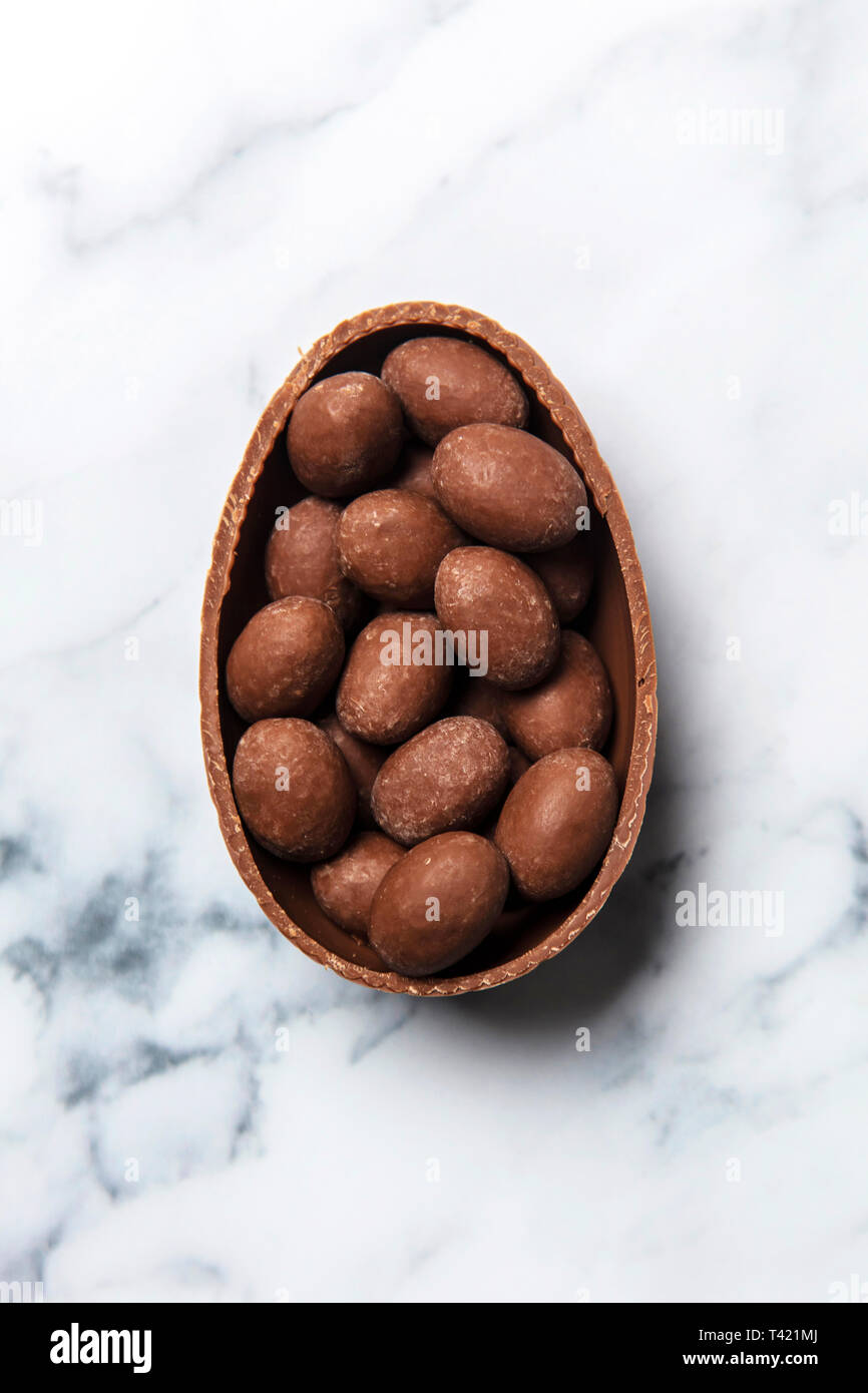 De pâques en chocolat rempli de mini oeufs sur un fond de marbre Banque D'Images