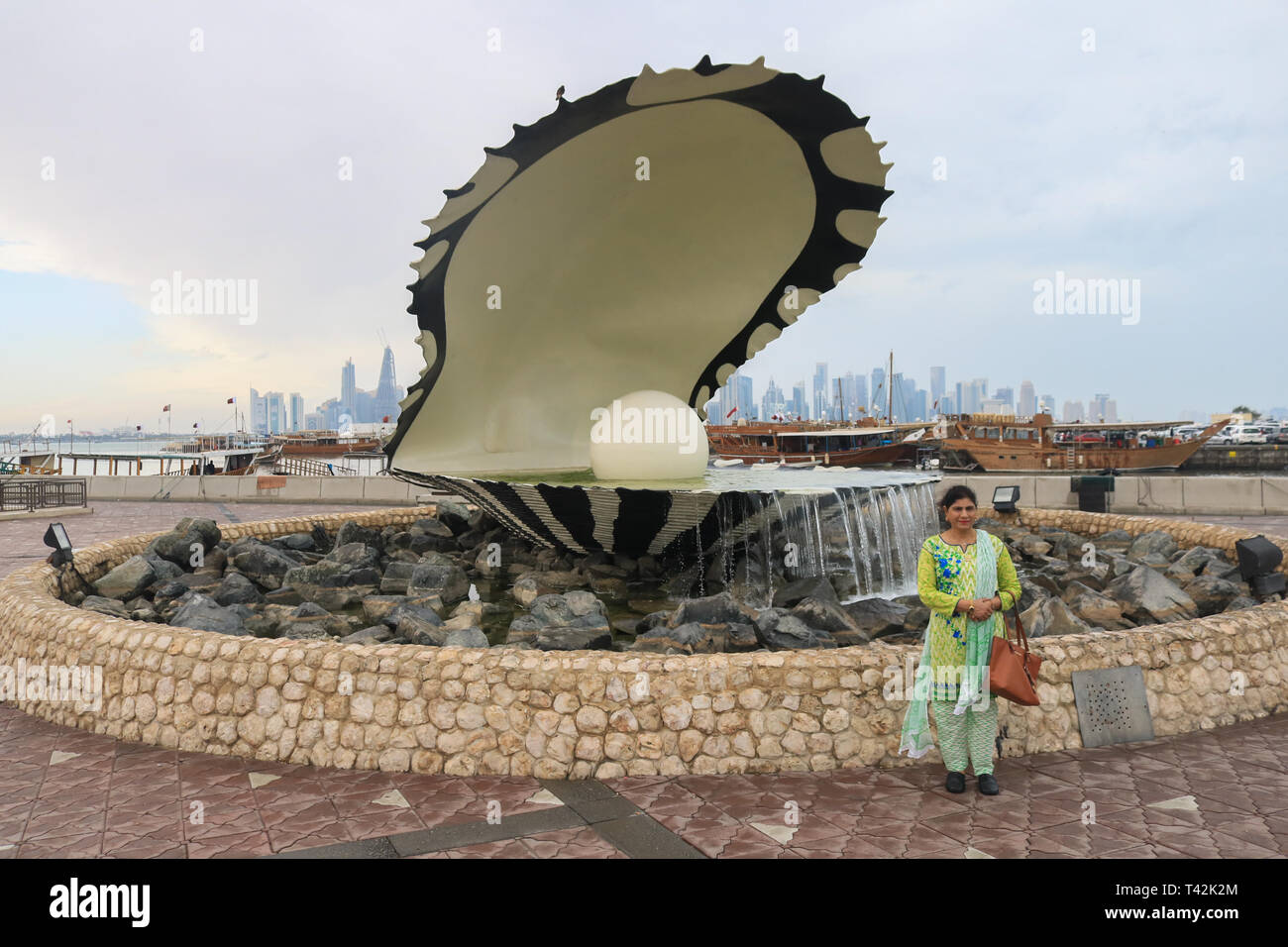 Doha, Qatar. 13 avr, 2019. Un touriste pose pour des photos en face d'une perle géante sculpture sur un matin pluvieux et humide dans le capital Crédit : amer ghazzal/Alamy Live News Banque D'Images