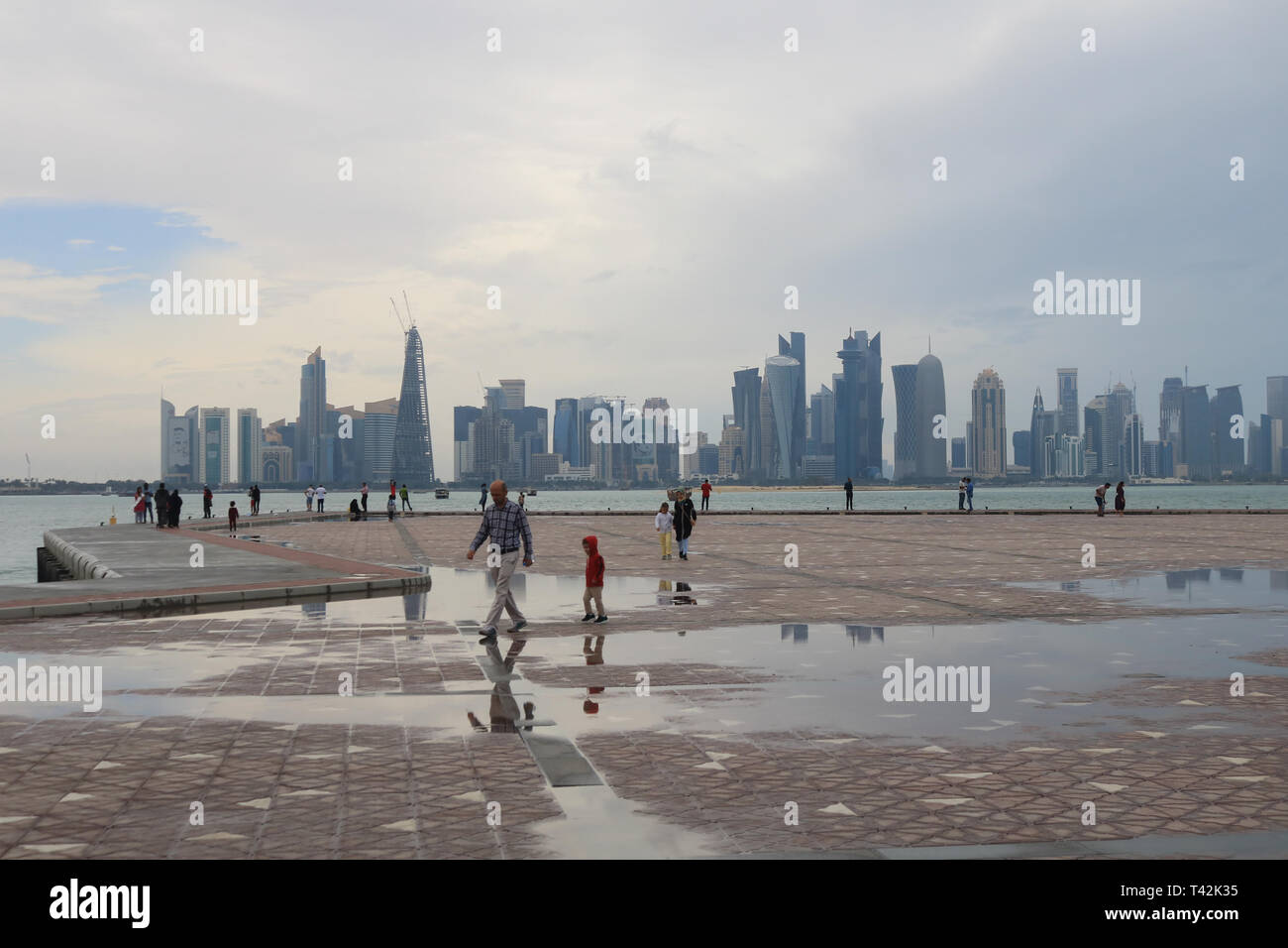 Doha, Qatar. 13 avr, 2019. Les gens à pied sur de grandes flaques sur le bord de l'eau après de fortes pluies le matin dans la capitale : Crédit amer ghazzal/Alamy Live News Banque D'Images