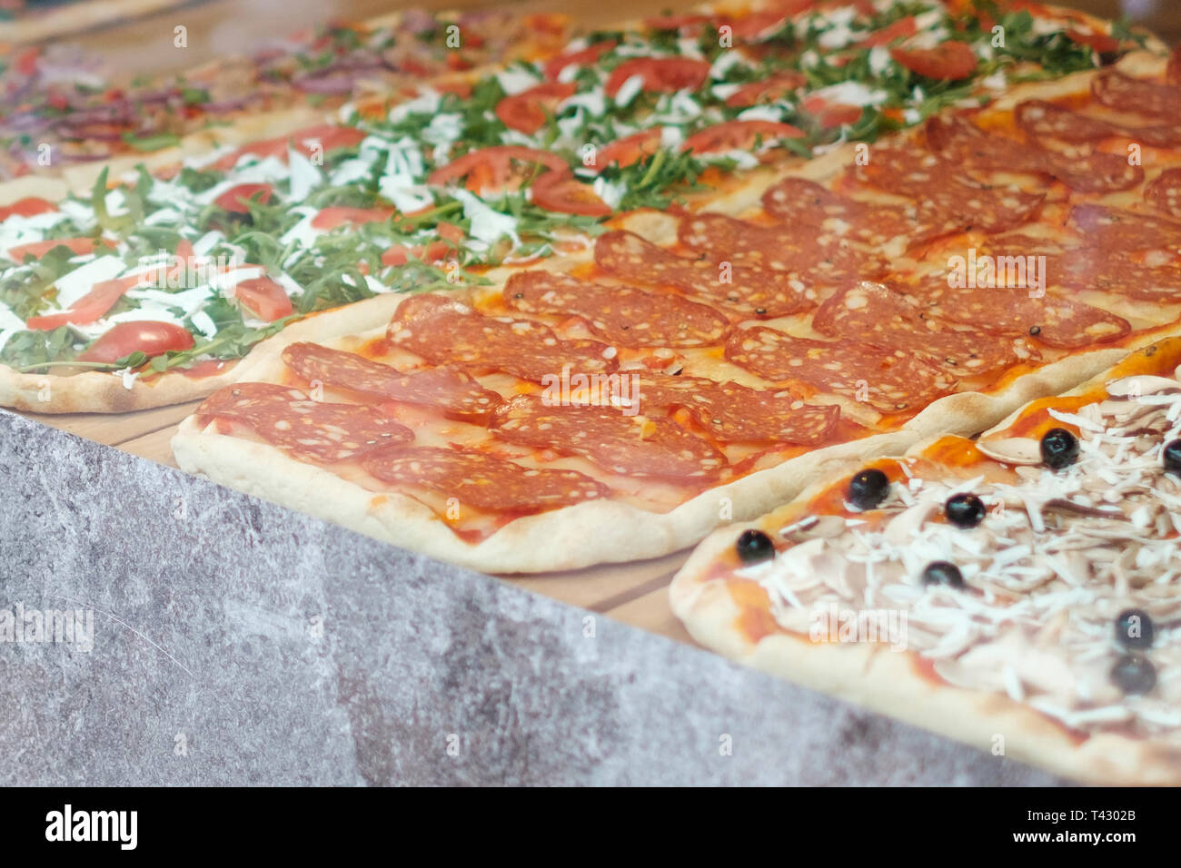 Pizza à la vente, tranche de pizza derrière la fenêtre d'affichage Banque D'Images