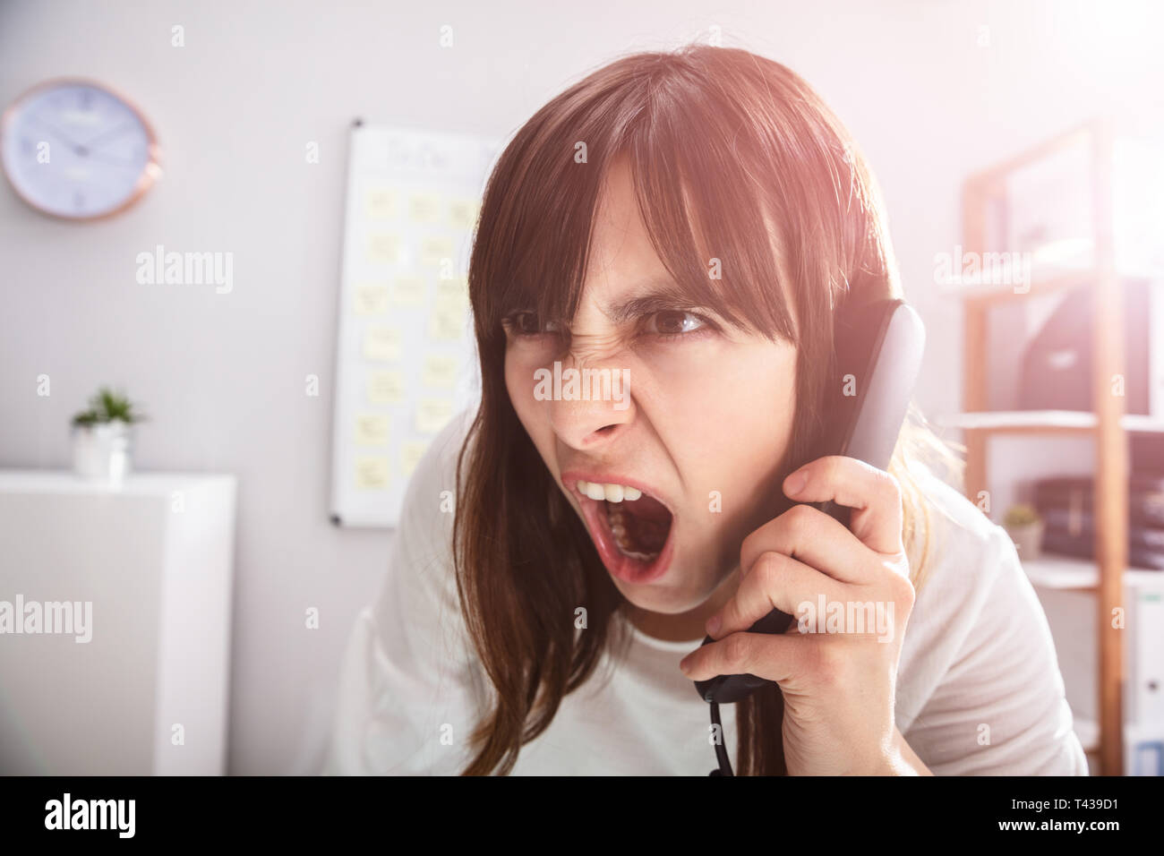 Portrait d'un choqué Businesswoman Talking On Telephone Banque D'Images