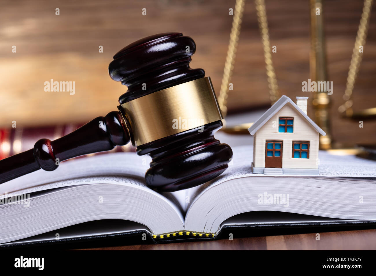 Close-up of Miniature House and Gavel On Open Book Banque D'Images