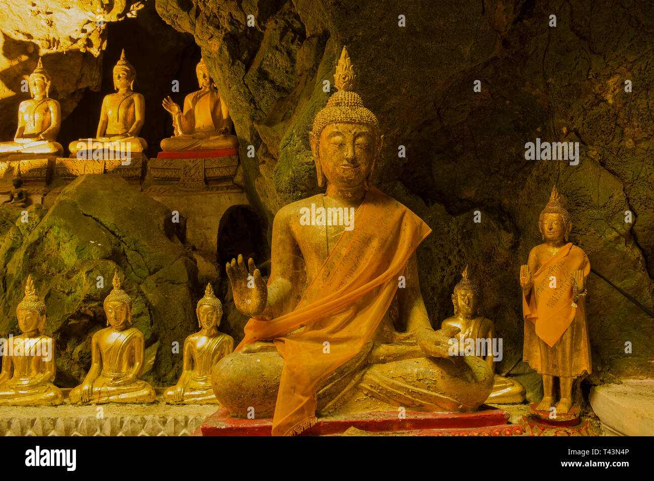 Plusieurs anciennes sculptures d'un Bouddha assis à l'intérieur de la grotte temple de Wat Tham Khao Luang. Phetchaburi, Thailand Banque D'Images