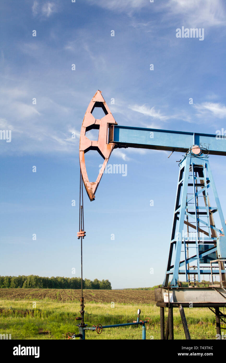 Industrie du pétrole et du gaz. De travail sur un champ de pétrole. Green field and blue sky Banque D'Images