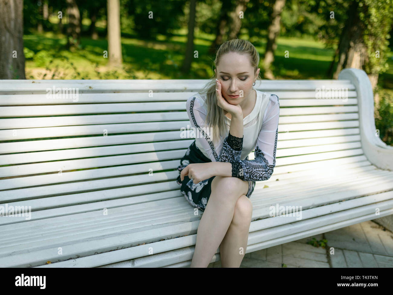 Triste femme seule sur un banc de parc. Banque D'Images