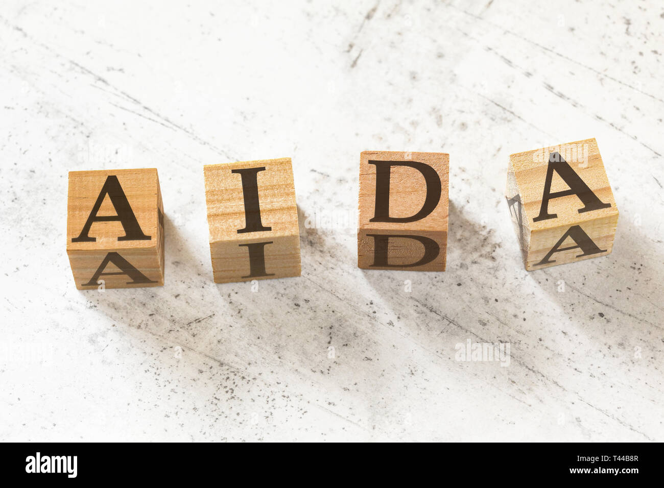 Quatre cubes en bois avec des lettres AIDA Attention sens intérêt Désir de sensibilisation sur l'Action du conseil de travail d'un blanc. Banque D'Images