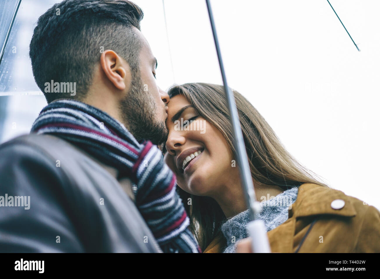 Heureux dancer dans un jour de pluie - bel homme embrasser son front petite amie sous la pluie - l'amour, les gens, la relation concept Banque D'Images