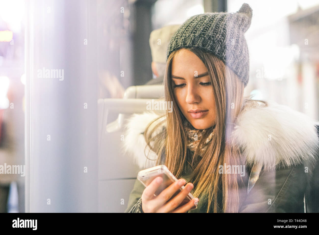 Jeune femme à l'aide de son téléphone intelligent tout en restant assis dans un bus - jolie fille se connecter sur son réseau social avec son téléphone portable Banque D'Images