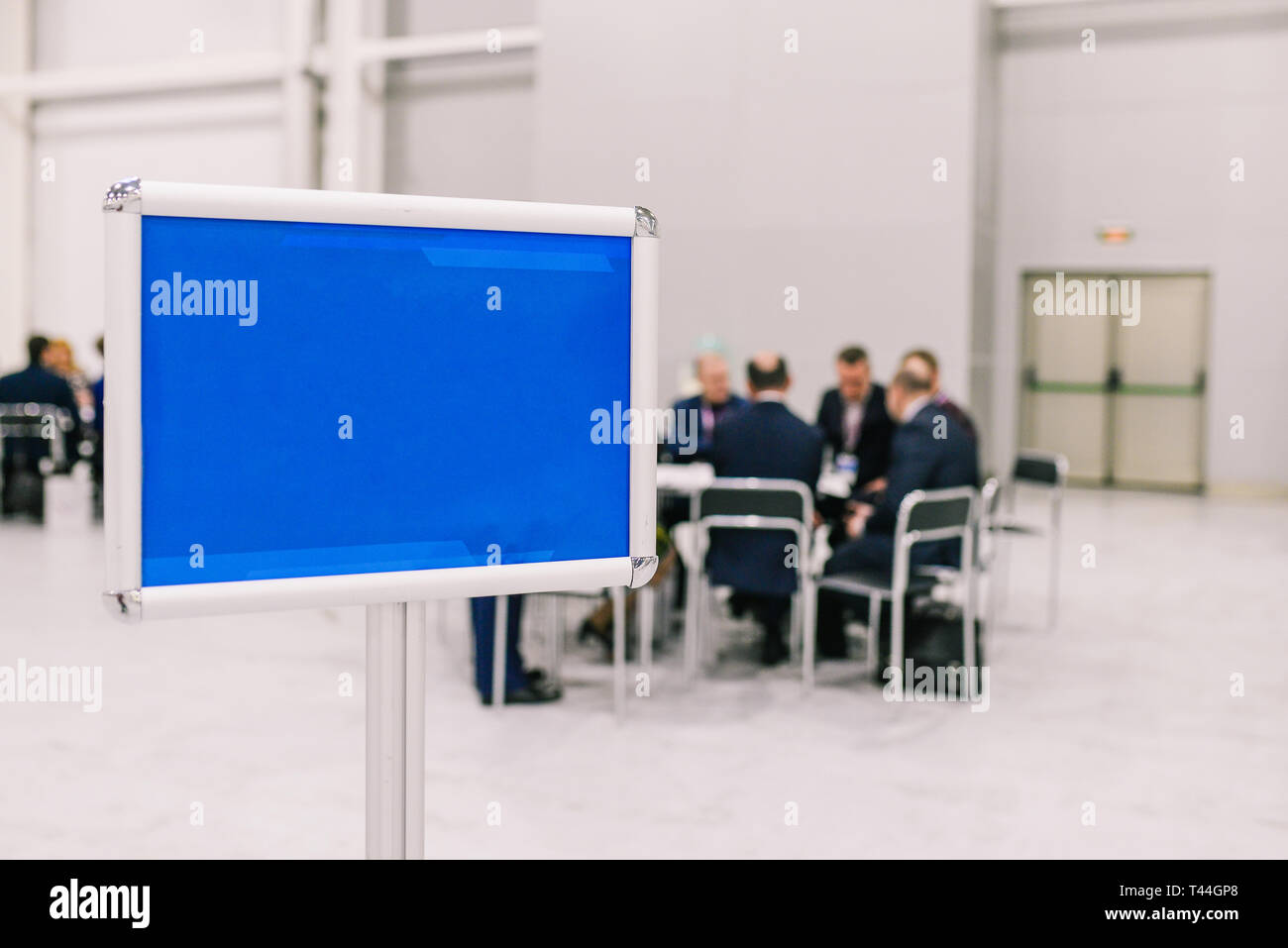 Un groupe de personnes discutent d'un projet. Les hommes de négocier à la table. Plaque bleu vide. Le personnel et les collègues de la réunion Banque D'Images