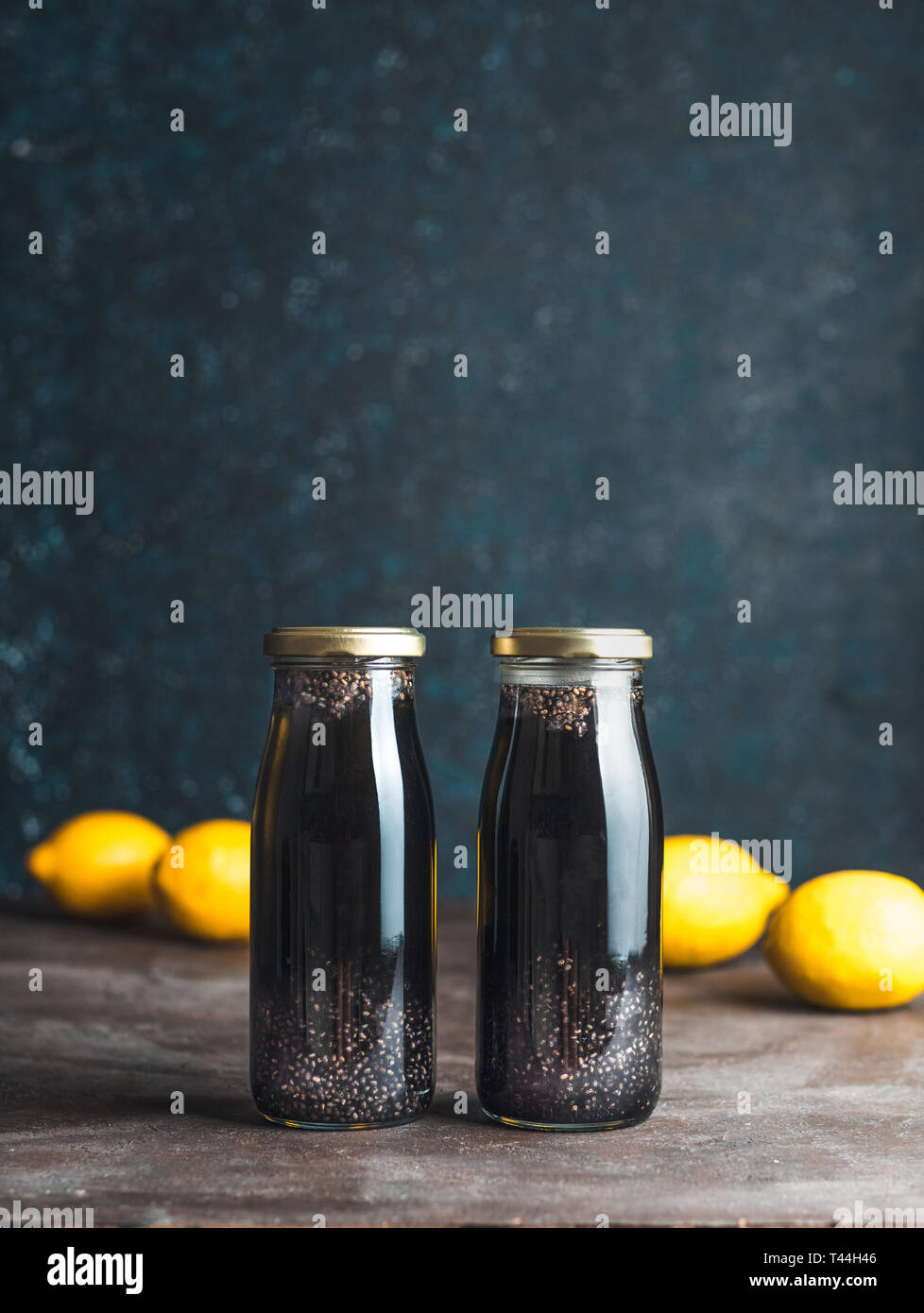 Detox noir charbon activé ou l'eau de chia au citron limonade. Deux bouteille avec de l'eau infusée chia noir. Boisson Detox idée et recette. Vegan Aliments et boissons. La verticale. Banque D'Images