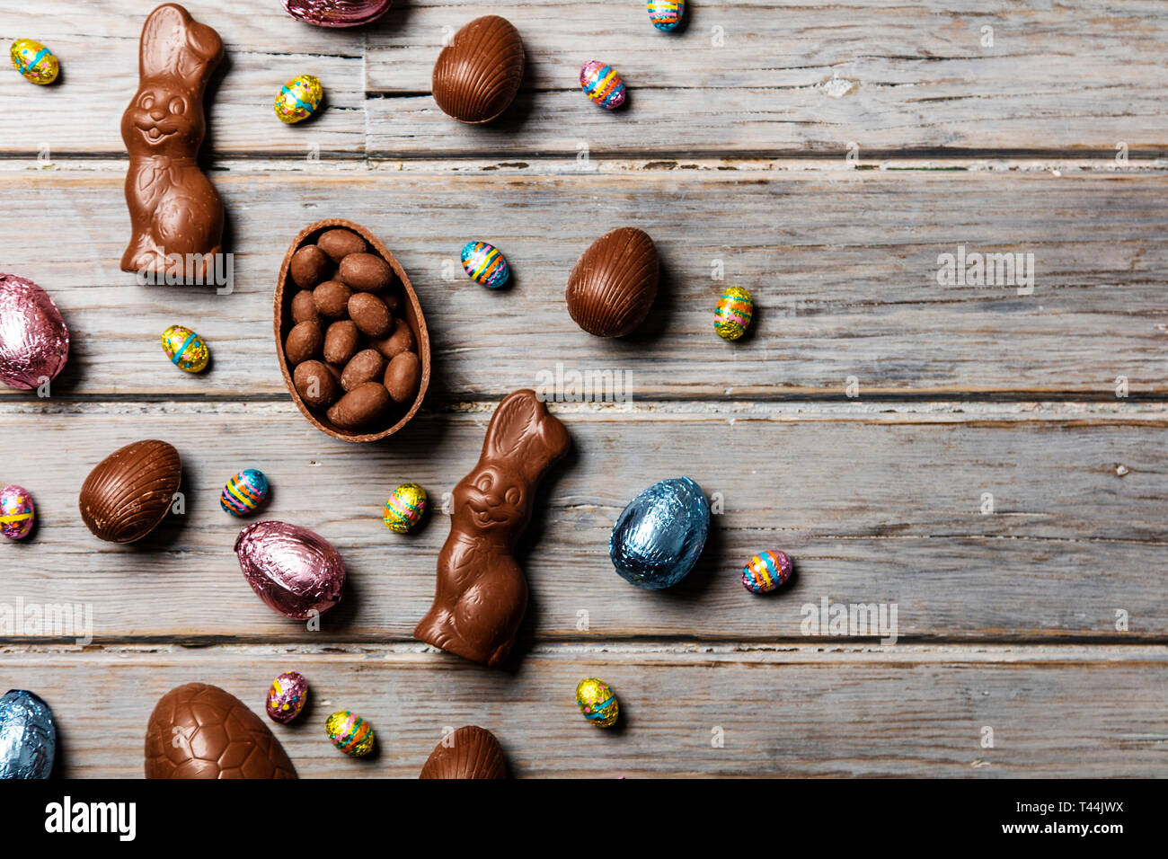 Les oeufs de pâques en chocolat et les lapins sur un fond de bois rustique Banque D'Images