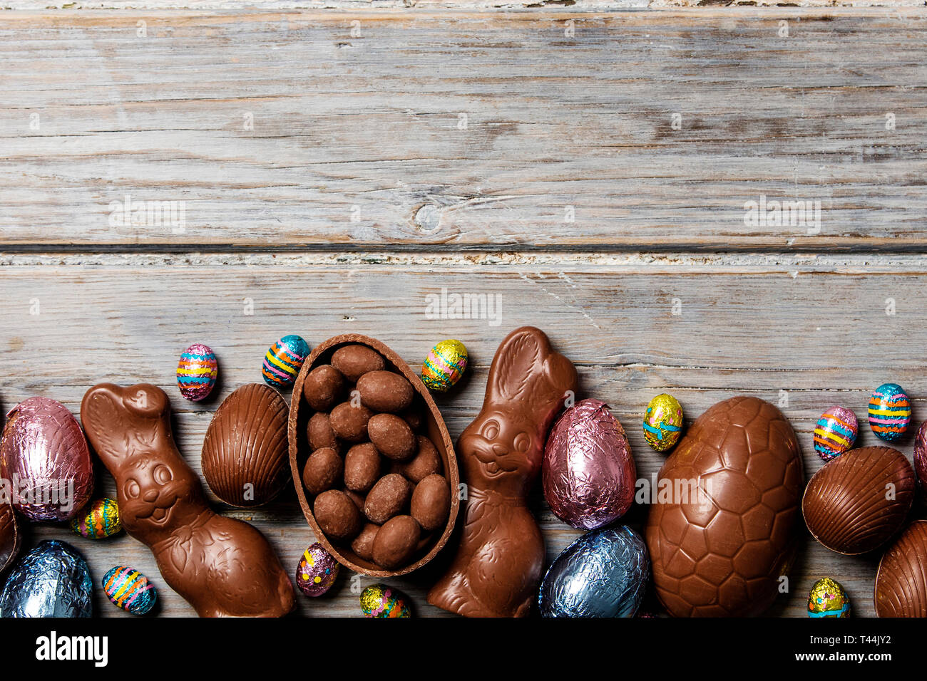 Les oeufs de pâques en chocolat et les lapins sur un fond de bois rustique Banque D'Images