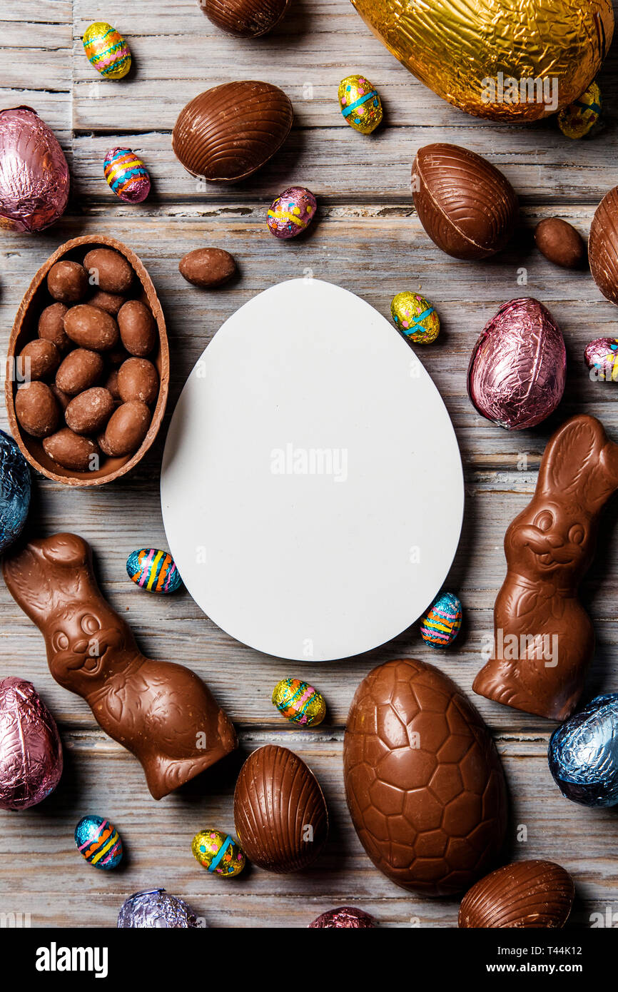 Les oeufs de pâques en chocolat et les lapins sur un fond de bois rustique Banque D'Images