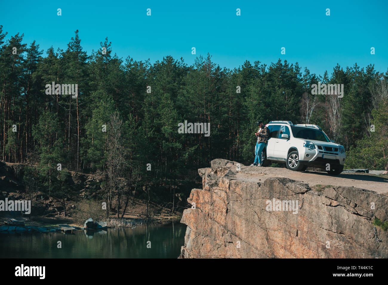 Jeune homme à bord avec vue magnifique sur le lac près de white suv voiture. copie espace temps de l'aventure. Banque D'Images