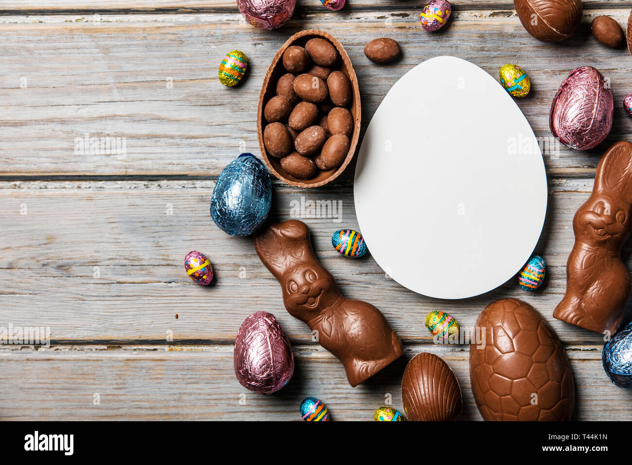 Les oeufs de pâques en chocolat et les lapins sur un fond de bois rustique Banque D'Images