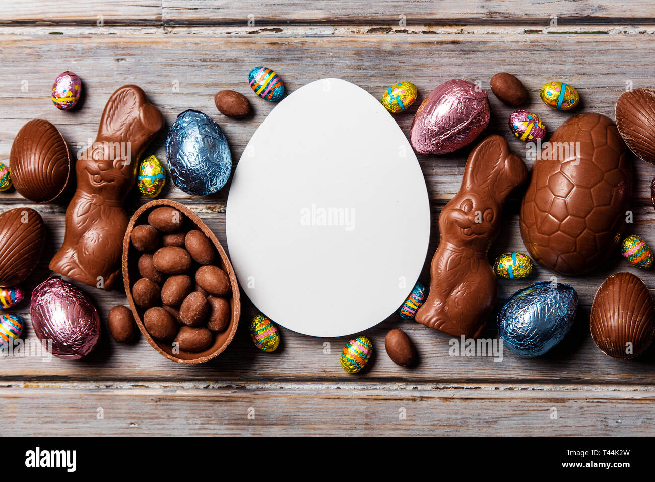 Les oeufs de pâques en chocolat et les lapins sur un fond de bois rustique Banque D'Images