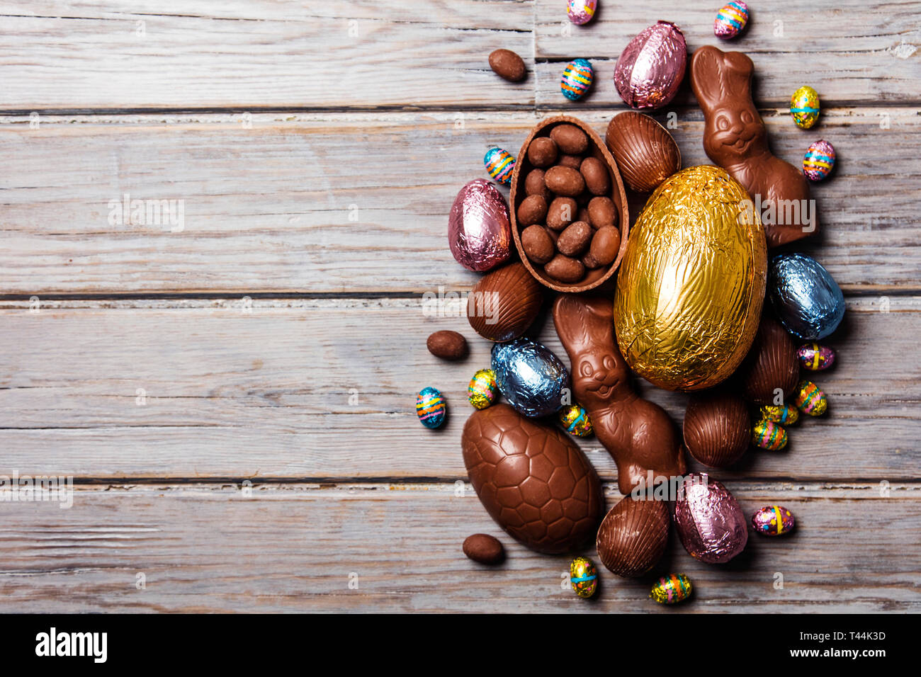 Les oeufs de pâques en chocolat et les lapins sur un fond de bois rustique Banque D'Images