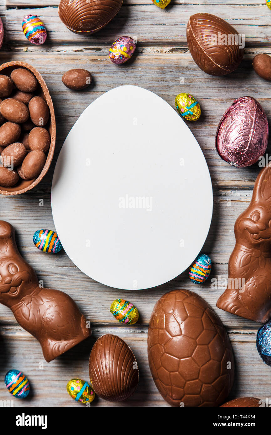 Les oeufs de pâques en chocolat et les lapins sur un fond de bois rustique Banque D'Images