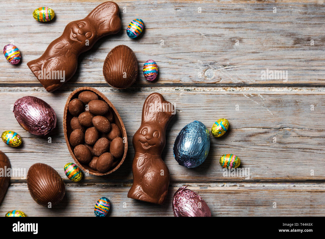 Les oeufs de pâques en chocolat et les lapins sur un fond de bois rustique Banque D'Images