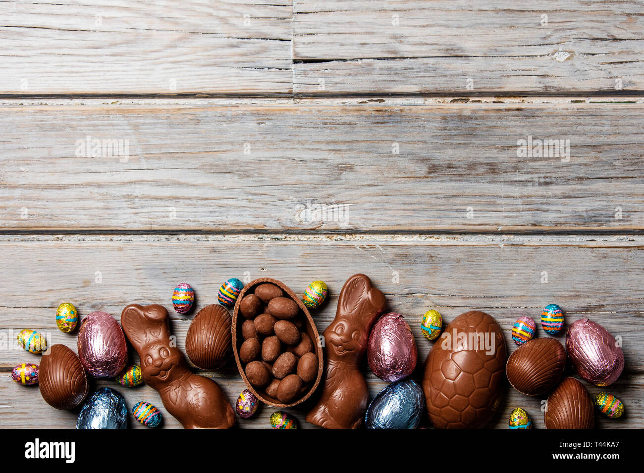 Les oeufs de pâques en chocolat et les lapins sur un fond de bois rustique Banque D'Images