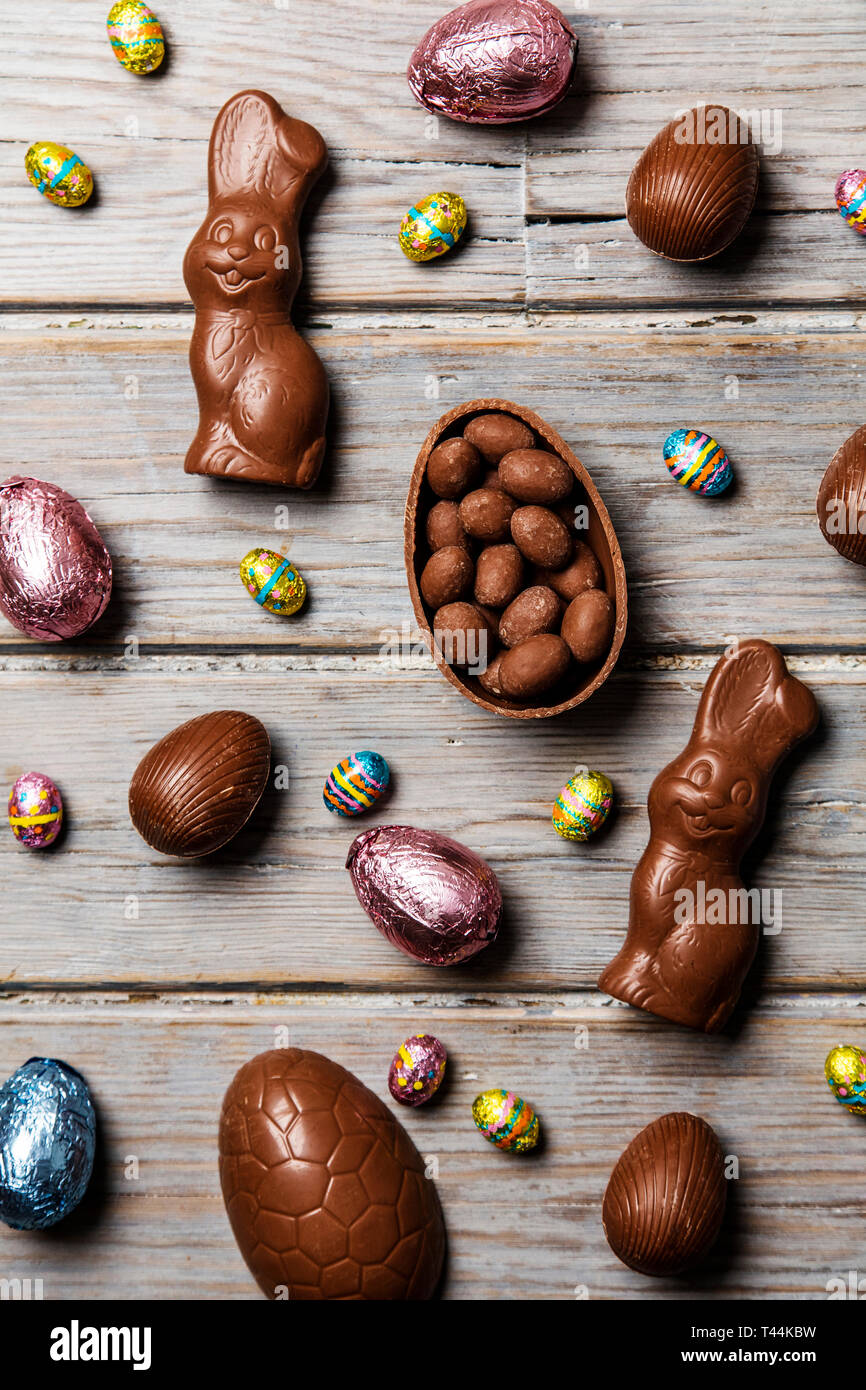 Les oeufs de pâques en chocolat et les lapins sur un fond de bois rustique Banque D'Images