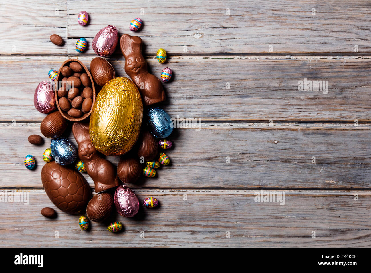 Les oeufs de pâques en chocolat et les lapins sur un fond de bois rustique Banque D'Images