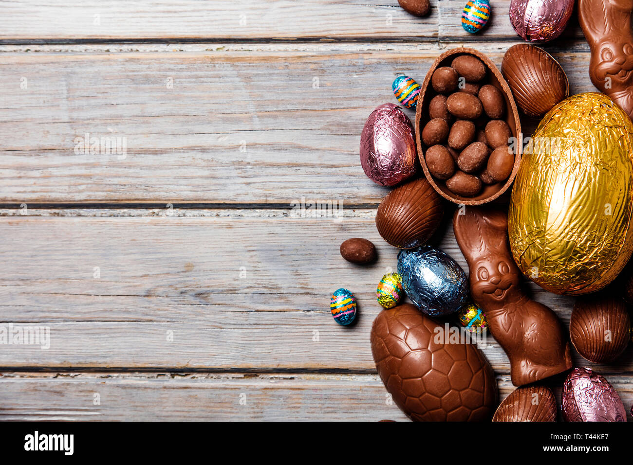 Les oeufs de pâques en chocolat et les lapins sur un fond de bois rustique Banque D'Images
