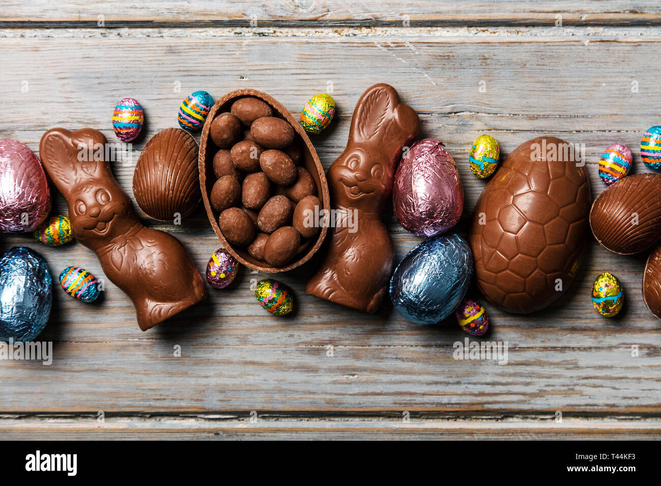 Les oeufs de pâques en chocolat et les lapins sur un fond de bois rustique Banque D'Images