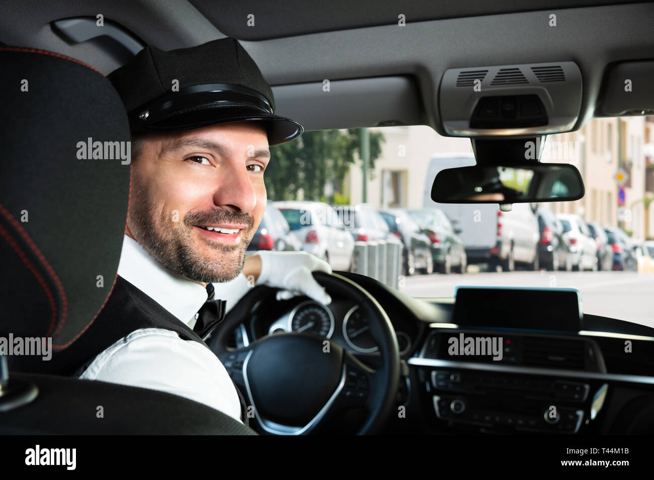 Portrait d'un homme heureux voiture avec chauffeur assis à l'intérieur Banque D'Images