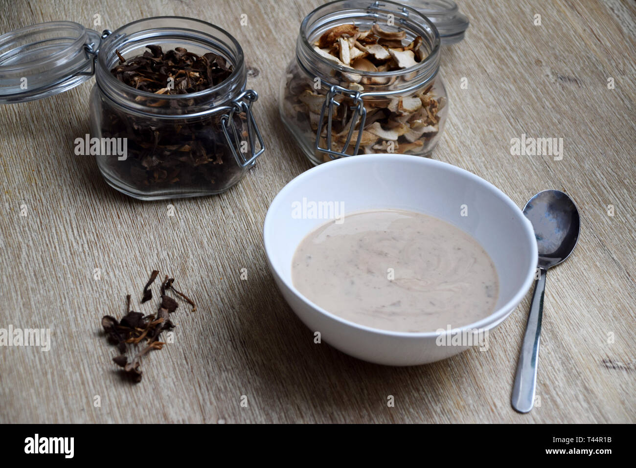Soupe aux champignons dans un bol et les contenants de verre avec des champignons séchés Banque D'Images
