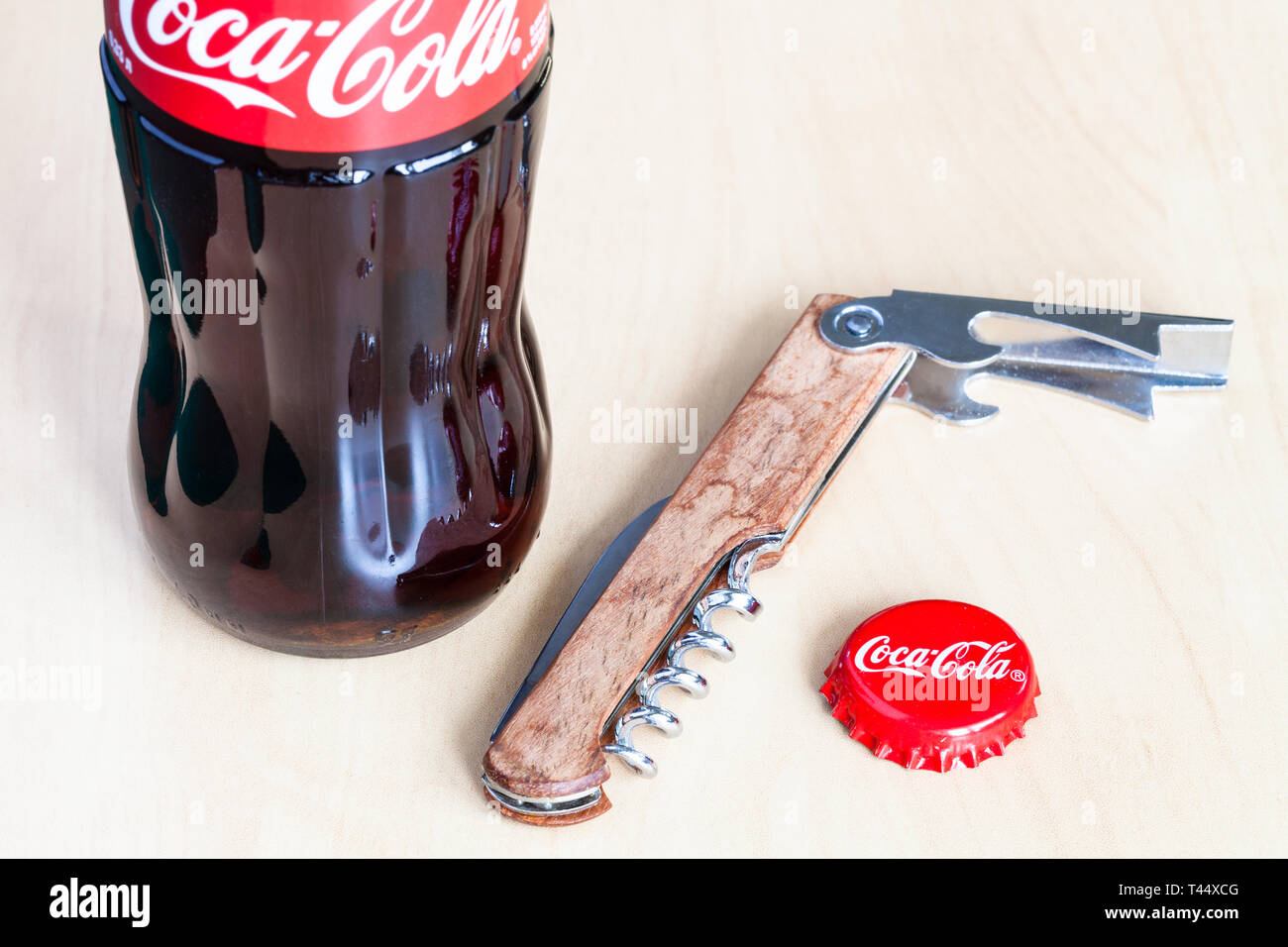 Moscou, Russie - le 4 avril 2019 : Coca-Cola bouteille de verre, utilisé couronne silicone sur planche de bois. Coca-Cola (coke) est ma boisson gazeuse Banque D'Images
