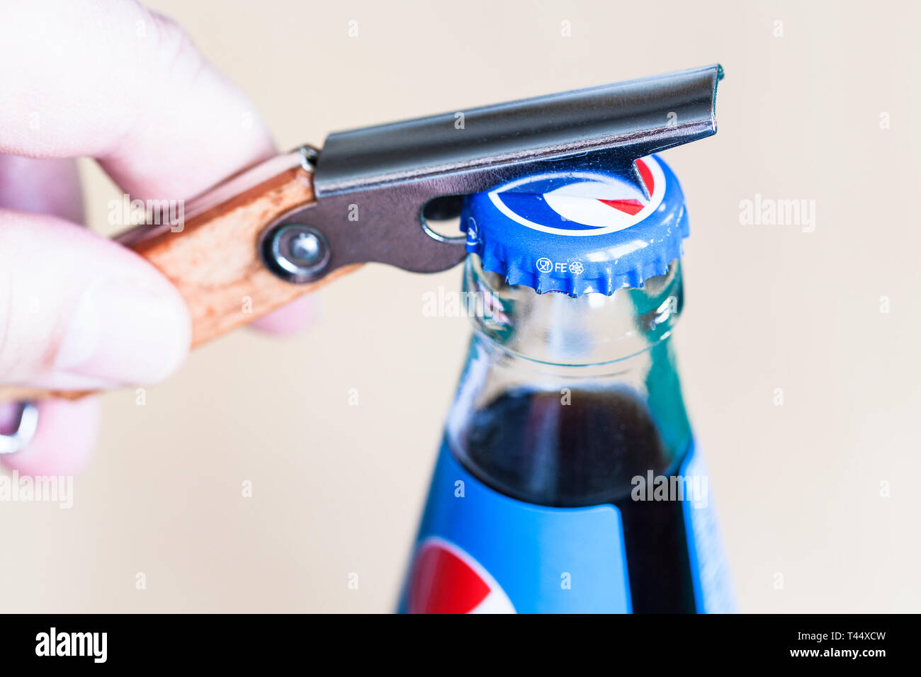 Moscou, Russie - le 4 avril 2019 : l'ouverture d'un bouchon de bouteille en verre de Pepsi par ouvre-bouteille close up. Boisson gazeuse Pepsi est fabriqué par PepsiCo Banque D'Images