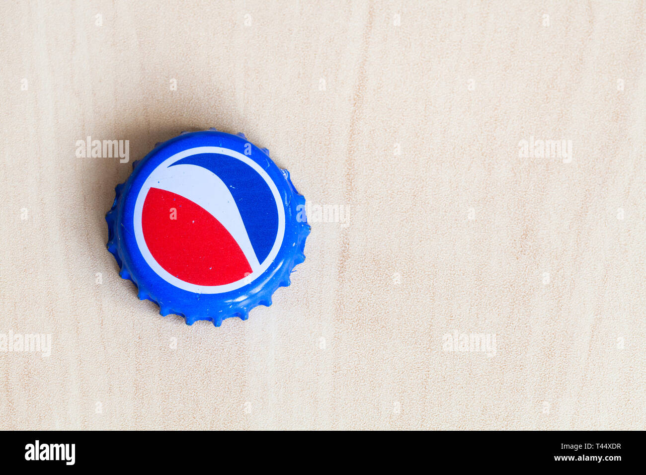 Moscou, Russie - le 4 avril 2019 : Crown Cork bouchon de la bouteille de boisson Pepsi sur planche de bois avec copyspace. Boisson gazeuse Pepsi manufact Banque D'Images