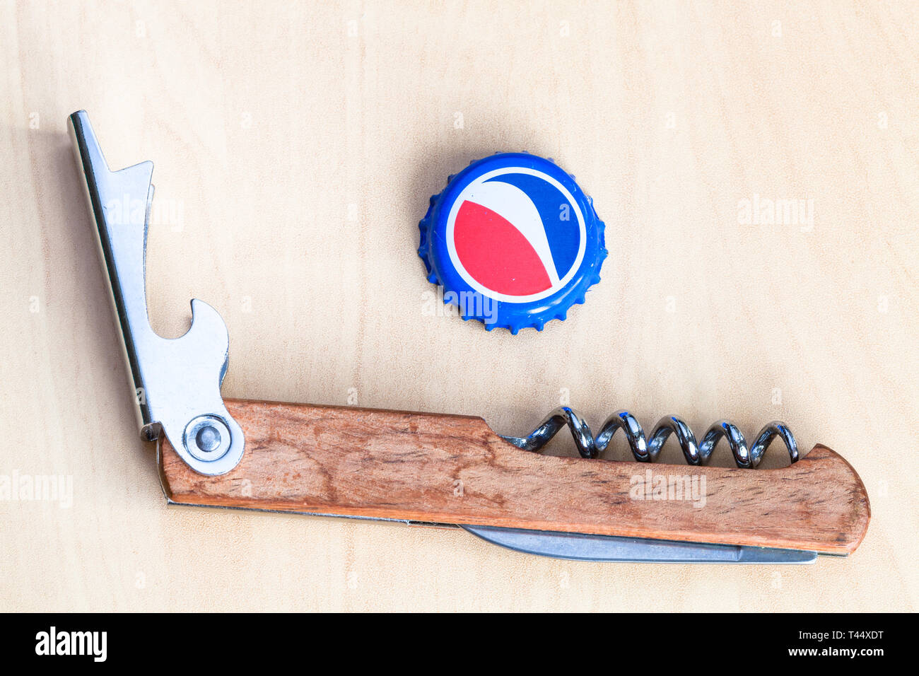 Moscou, Russie - le 4 avril 2019 : Crown Cork bouchon de la bouteille de boisson Pepsi et ouvre-bouteille sur planche de bois. Boisson gazeuse Pepsi est fabr Banque D'Images