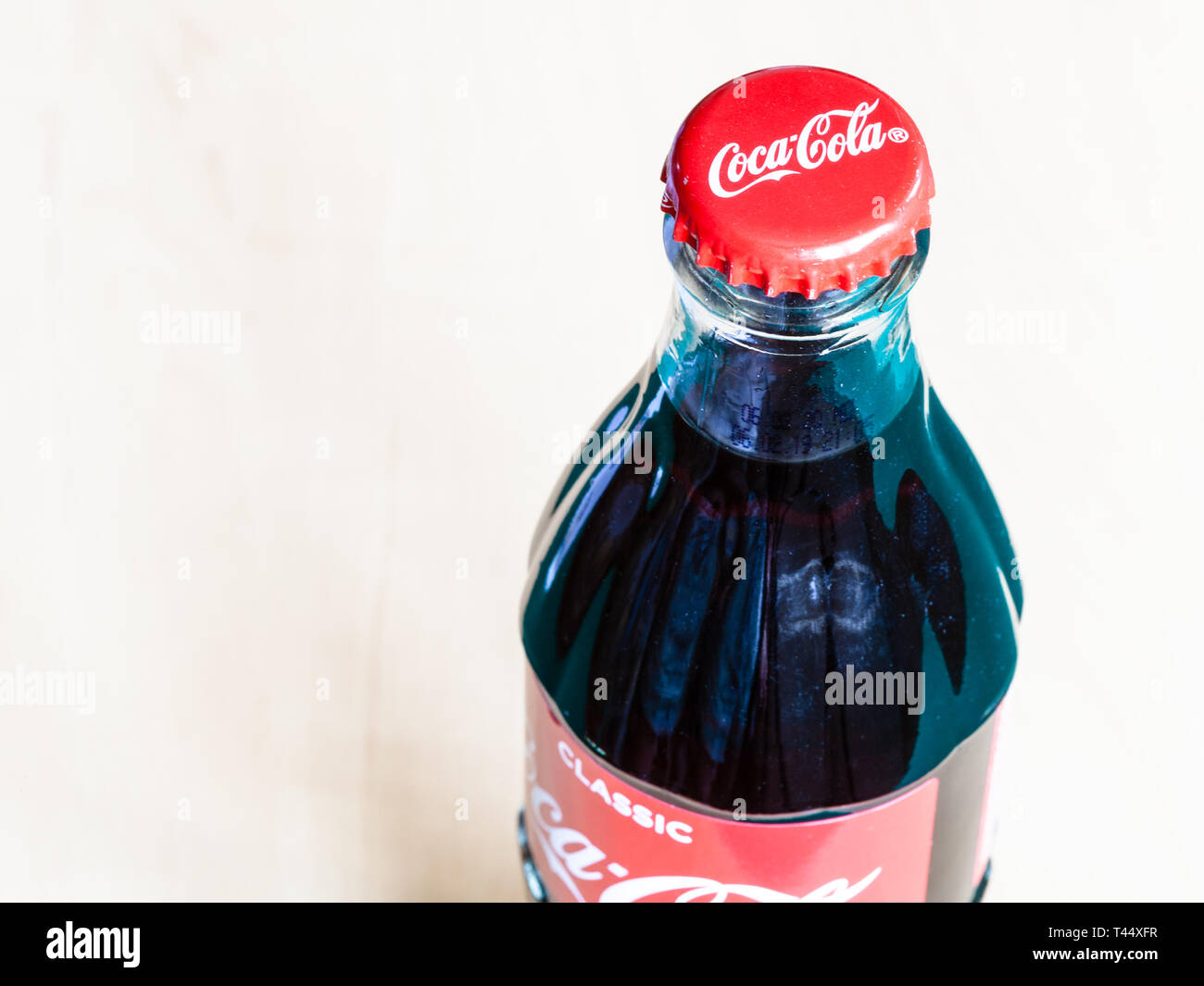 Moscou, Russie - le 4 avril 2019 : voir ci-dessus de bouteille en verre Coca-Cola fermé sur table en bois. Coca-Cola (coke) Boisson gazeuse est fabriqué par Banque D'Images